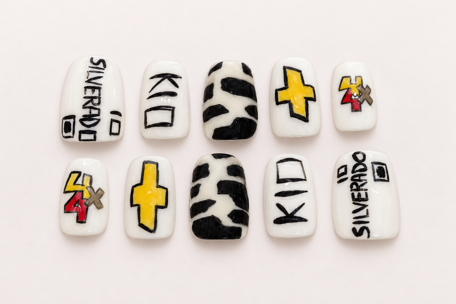 Chevy truck inspired nails with gold bowtie emblems, Silverado lettering, and black and white accents